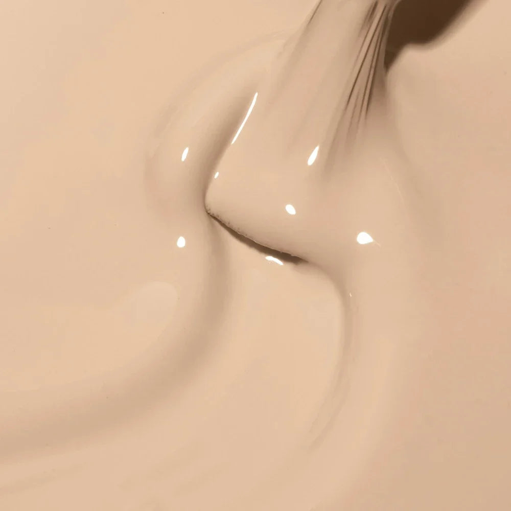 Color crema lechoso muy claro del esmalte semipermanente Cupio Milky Truffle sobre el pincel, textura cremosa