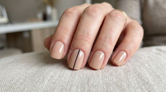 Nail art minimalista profesional: uñas nude con línea fina negra en diseño limpio