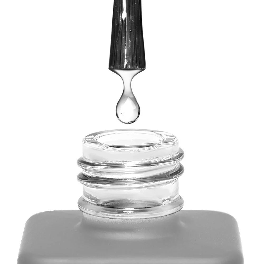 Pincel del deshidratador Cupio Nail Prep dejando caer una gota de líquido transparente sobre el frasco