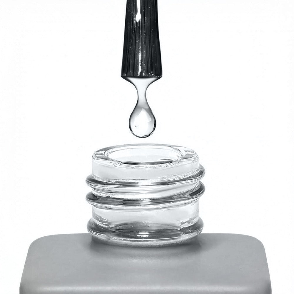 Pincel del primer sin ácido Cupio Nail Bonder dejando caer una gota de líquido transparente