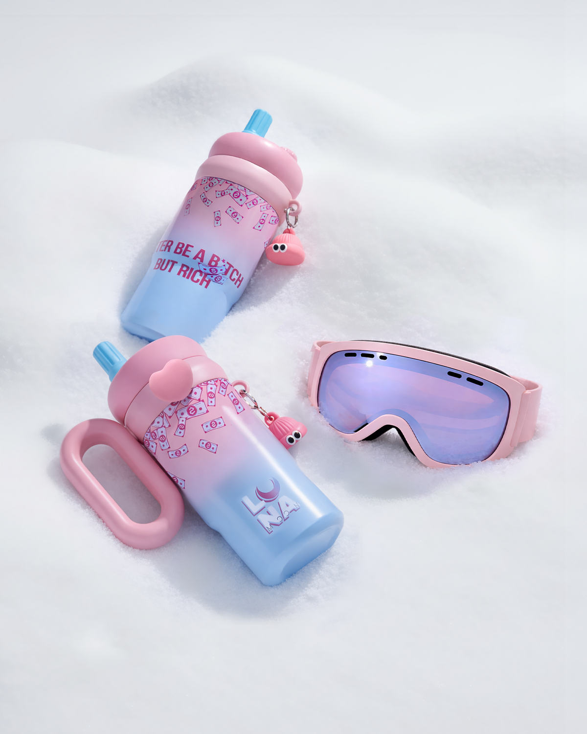 Dos termos LUNAmoon tumbados sobre nieve junto a unas gafas de esquí rosas